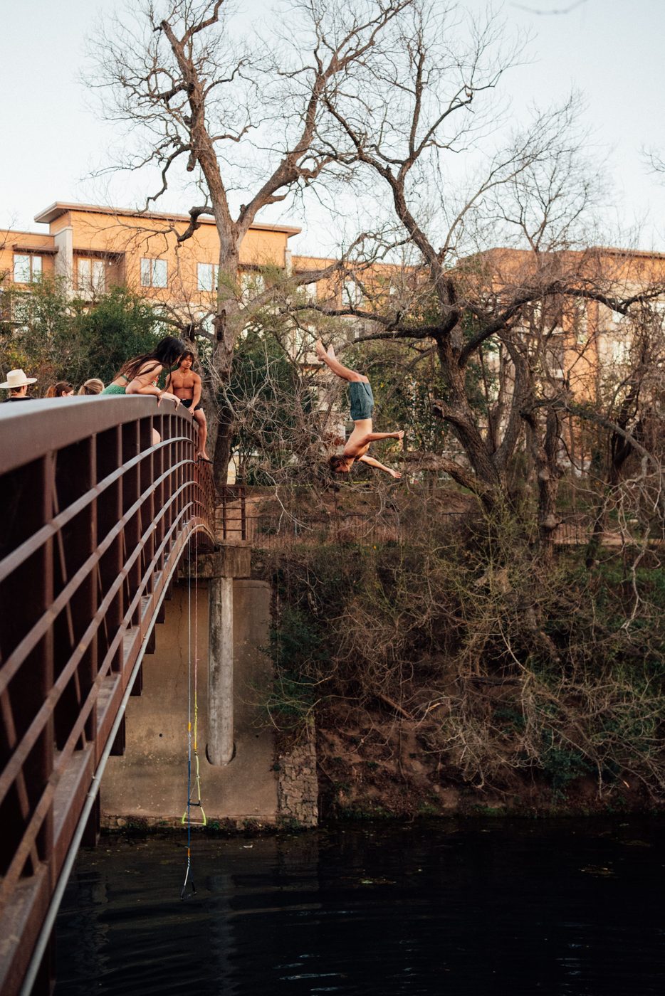Joe mid-flip diving from a bridge