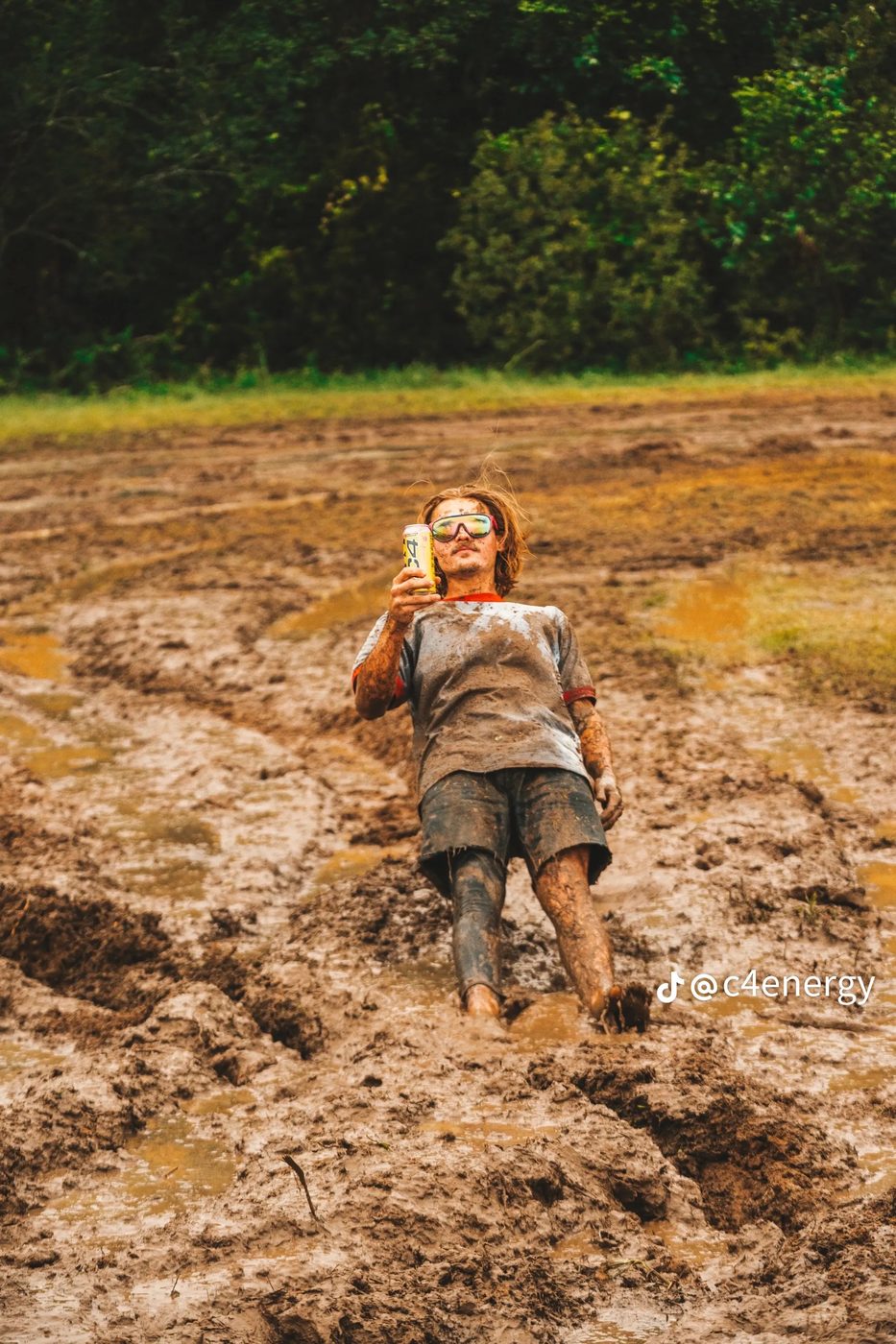 Joe mud-covered, holding a C4 can at the camera